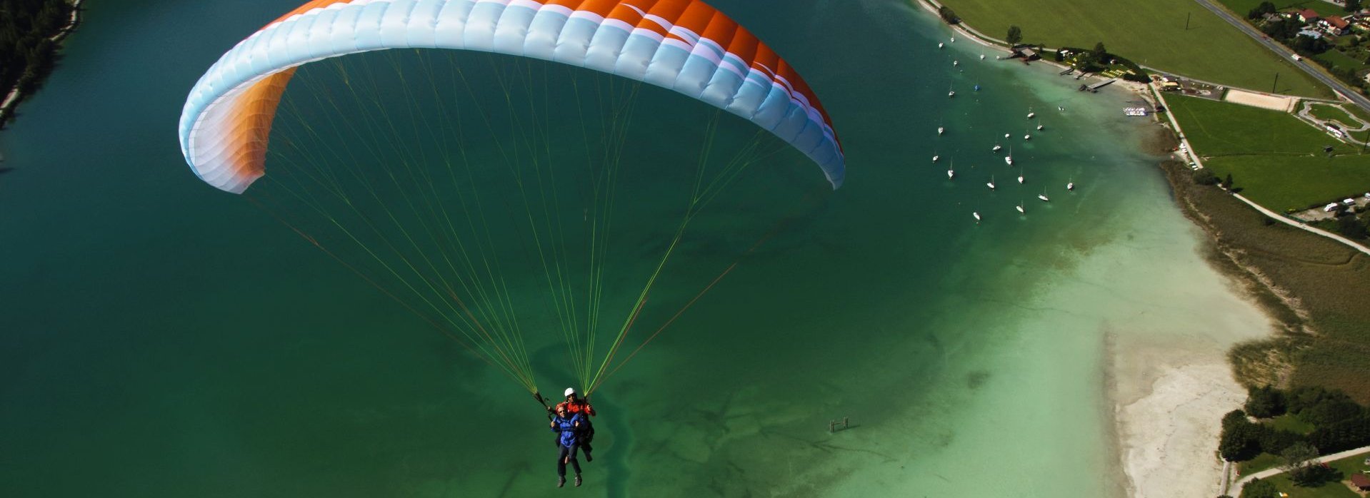 Ein Paraglider schwebt über dem Achensee.
