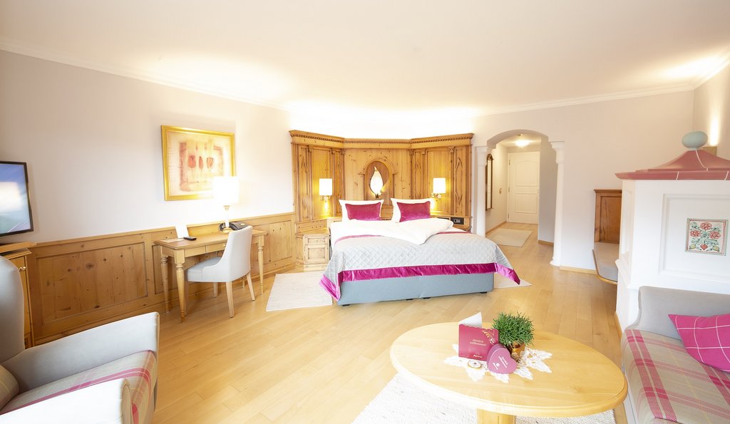 Blick in ein helles Hotelzimmer mit pinken Akzenten.