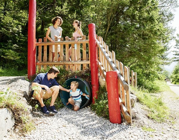 Eine Familie spielt zusammen auf einem Spielplatz.