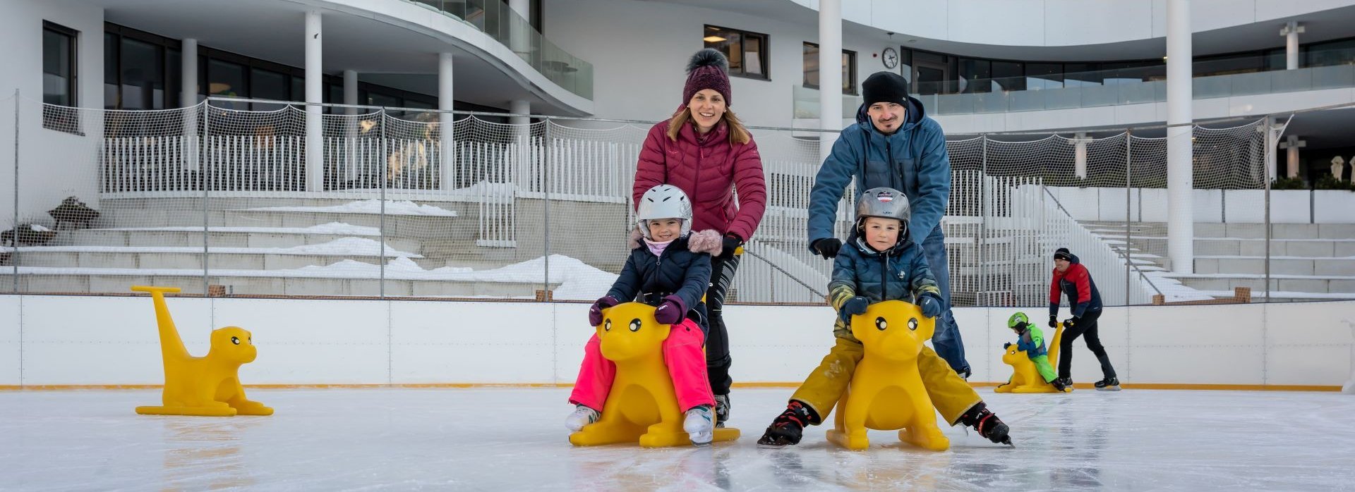 Eltern mit ihren Kindern auf dem Eislaufplatz.