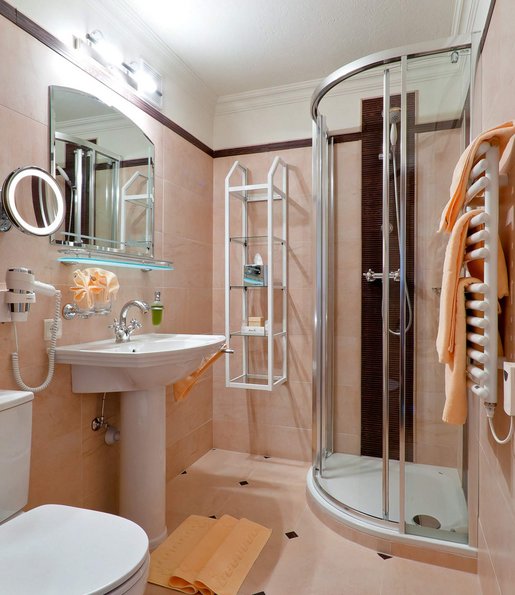 Kleines Badezimmer mit Toilette, Waschbecken und Dusche.