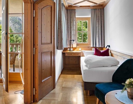 Ein Einzelzimmer mit gemütlichem Einzelbett und Balkon.