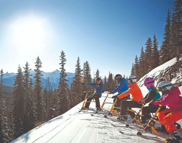 Eine Gruppe auf Snowbikes im Schnee.