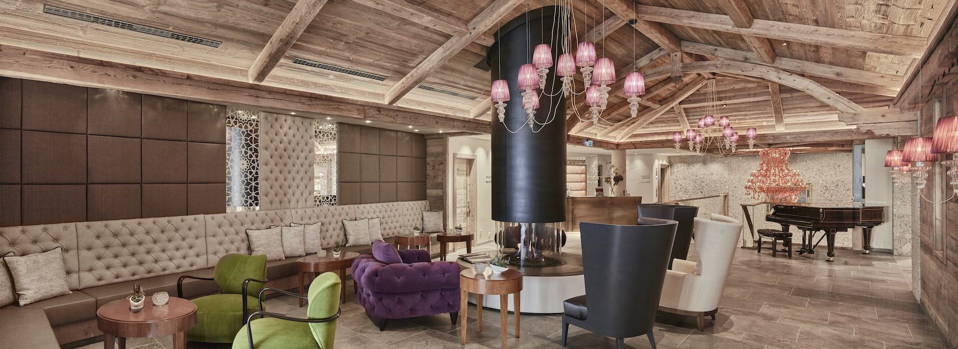 Aufenthaltsbereich mit Sitzmöglichkeit, Kamin und Klavier in der Cocoon Alpine Boutique Lodge.