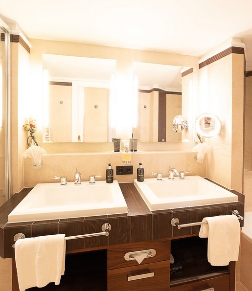 Ein Badezimmer mit zwei Waschbecken, einer Badewanne und einer Dusche. 