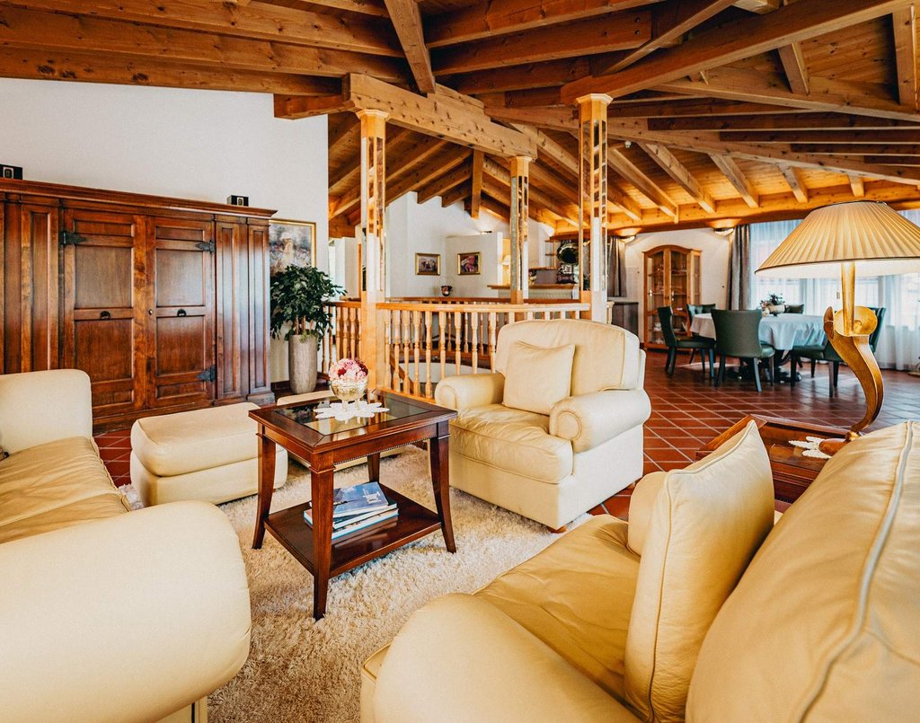 Weißes Ledersofa und Sessel im Wohnbereich einer Villa.