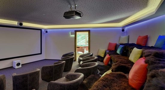 Heimkino mit großer Leinwand und mehreren Sitzmöglichkeiten.