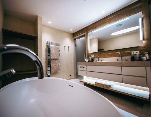 Luxuriöses Badezimmer mit Badewanne und großem Spiegel.