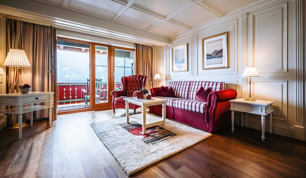 Ein rotes Sofa und ein roter Sessel in einem Hotelzimmer.