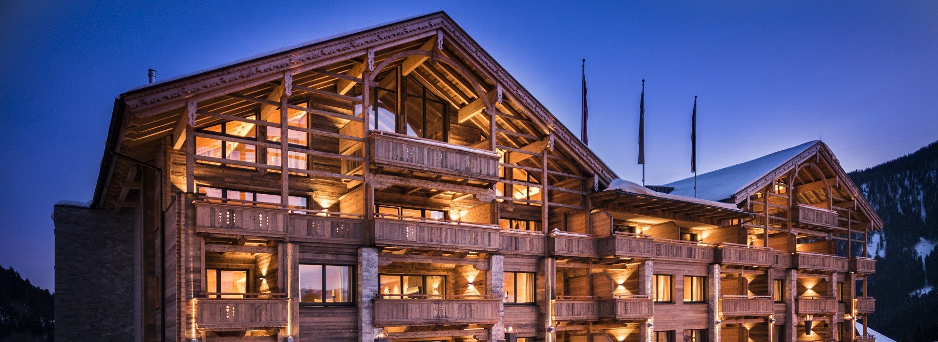 Die verschneite Cocoon Alpine Boutique Lodge bei Abenddämmerung.