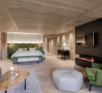 Blick in ein elegant eingerichtetes Hotelzimmer mit grünen Akzenten.